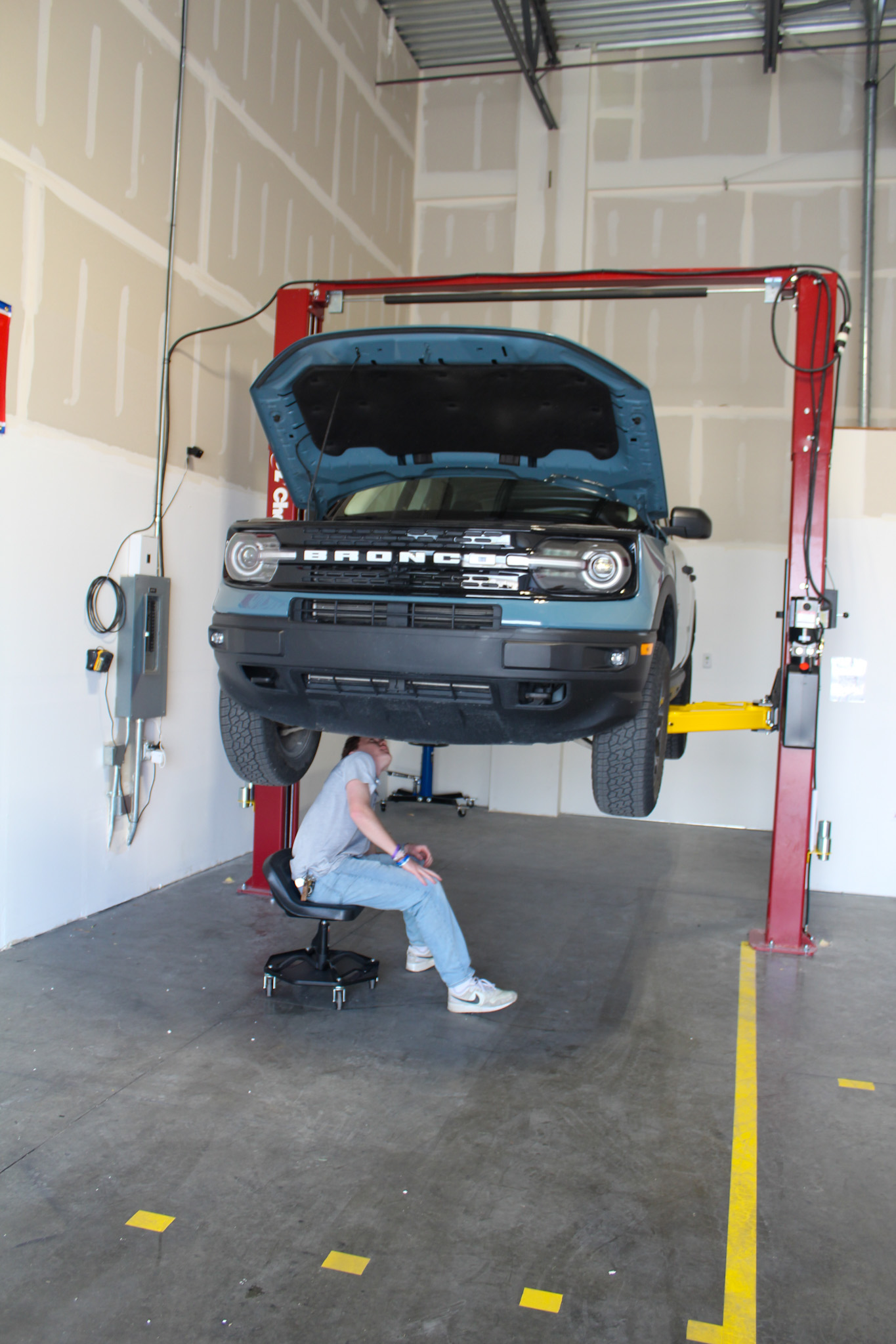 Car raised on a lift in a DIY garage bay