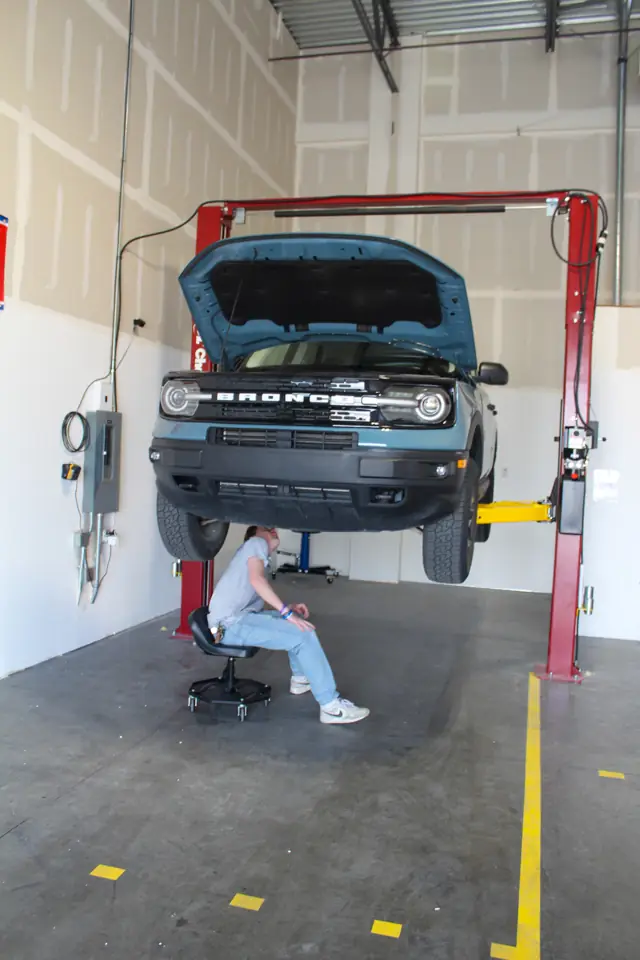 Car raised on a two-post lift in a Hafen's bay